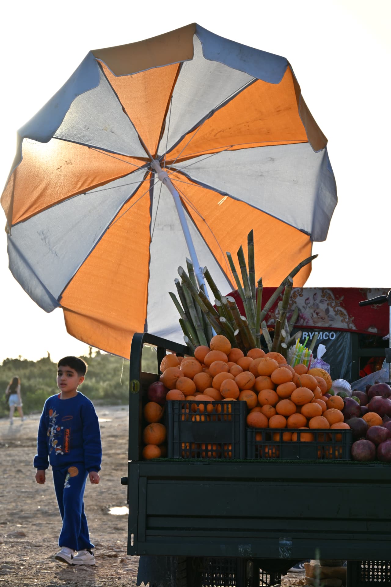 Sinaasappelkraam met parasol aan het strand